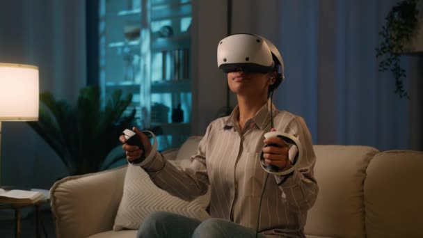 Vrヘッドセットヘルメットとコントローラーのアフリカ系アメリカ人女性は ビデオゲームの仮想現実を再生Ar現代技術は 夜の家庭の民族の女の子で3Dメガネでサイバー空間を探索します — ストック動画