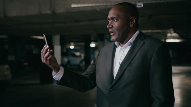 Злой Раздраженный Африканский Американец Разговаривает Видеосвязи Помощью Телефона Подземной Парковке — стоковое видео