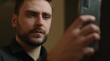 Kafkasyalı iş adamını kapat. Cep telefonu tut. Ekrana bak. Sosyal medya taraması web sitesi videosu izle.