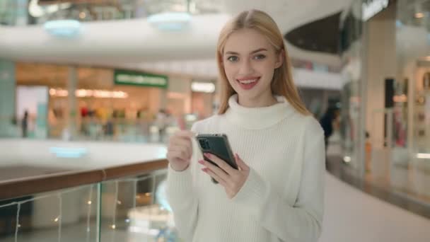 白种人女商人用手指在手机屏幕上指指点点满意的女人推荐新的智能手机女购物者在购物中心里使用手机小工具微笑的女士推广现代设备 — 图库视频影像