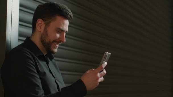 笑顔ビジネスセンターモールの白人男性ビジネスマンは スマートフォンでオンラインでモバイルアプリのチャットメッセージを使用して満足した幸せな男の男性クライアントの起業家オフィス予約で電話インターネットサーフィン — ストック動画