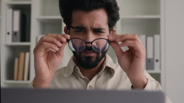 ラップトップビジネスの仕事のためのメガネの不健康なインドのアラビア人の男は悪い視力ぼやけた視界の目を持つビジネスマンのオフィスのCeoを混乱させる近視は眼鏡医療用眼レーザー補正損失視力を取る — ストック動画