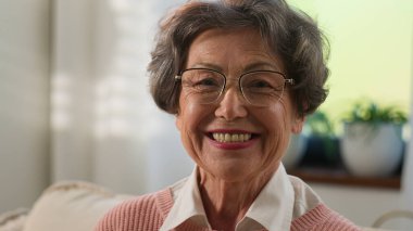 Büyükanne son sınıf öğrencisi yaşlı, olgun, yaşlı kadın, evde yaşlı, dişlek, gülümseyen kamera mutlu orta yaşlı, bekar, yaşlı, beyaz saçlı, neşeli, emekli kadın portresi.