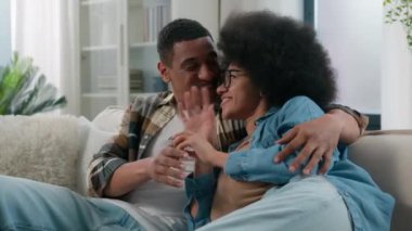 Yeni evimizde yaşayan Afrikalı Amerikan aile çifti mutlu erkek ve kadın muhabbetleri kanepede sohbet ediyorlar. Kanepede konuşuyorlar.