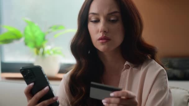 白人女の子動揺イライラ女性怒っている女性オンソファホールドクレジットカード使用モバイル銀行アプリの電話は オンライン銀行の問題を支払うしようとします — ストック動画