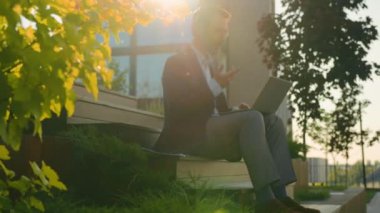 Gülümseyen işadamı işadamı öğretmenliği profesörü. Üniversite kampüsünde ders veriyor. Laptop ve kulaklık kullanıyor.