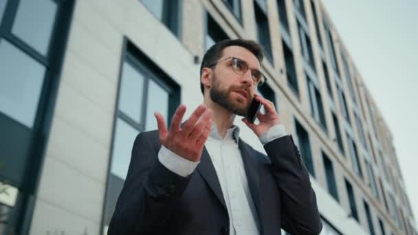白人ビジネスマン相談クライアント使用携帯電話遠隔通信屋外大人の男の答えオフィス会社の近くのビジネスの議論ダウンタウンの成功した雇用主の話のスマートフォン市内 — ストック動画