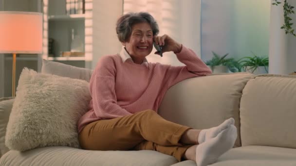 Mulher Velha Feliz Relaxando Sofá Aconchegante Falando Smartphone Sorrindo Avó — Vídeo de Stock
