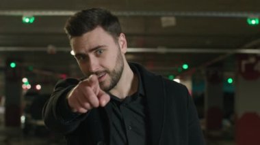 Caucasian smiling man point finger at camera choose you follow me gesture inviting to join happy male guy businessman driver in car parking invite asking to come here calling welcome beckoning appeal