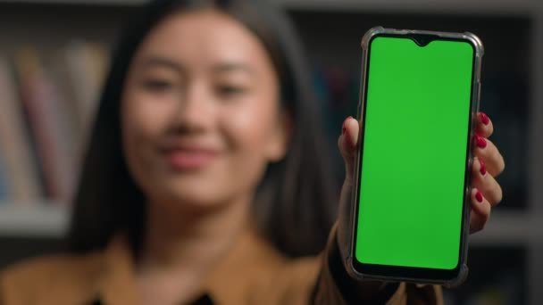 Uśmiechnięta Azjatka Dziewczyna Gospodarstwa Smartfon Pokazując Nowe Aplikacja Zbliżenie Zielony — Wideo stockowe