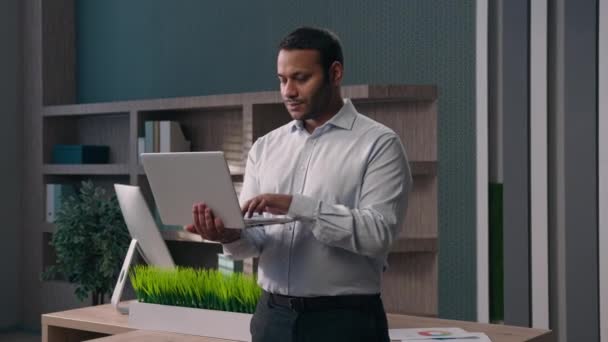 在公司工作单位工作的美国男性办公室职员公司的商人用电脑展示男子的工作经验在线商务建议同意很酷的好姿势支持拿着手提电脑 — 图库视频影像