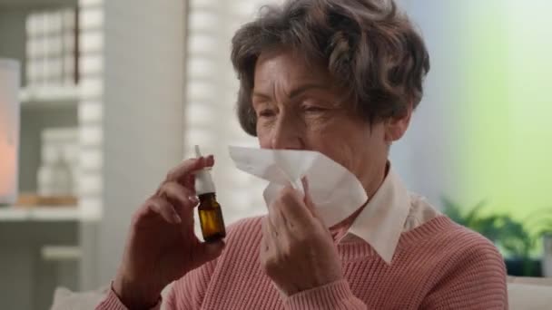 白种人生病的祖母打喷嚏在餐巾纸不舒服的老太太家里不健康的老太太打喷嚏老年老太太流鼻涕感冒过敏用鼻药喷 — 图库视频影像
