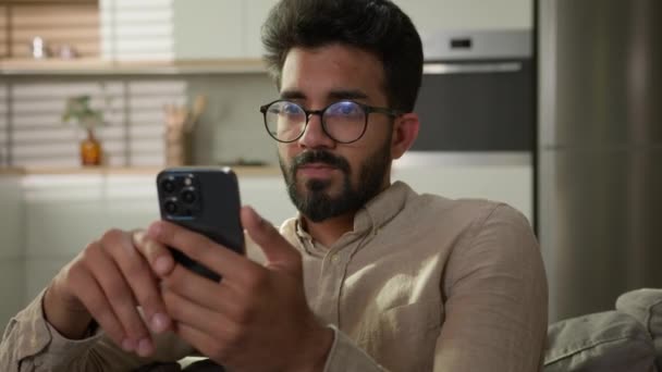 Arabian Indian Etnicznych Człowiek Używać Telefonu Komórkowego Kanapie Przeglądanie Mobilny — Wideo stockowe