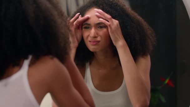 心配した若い美しいアフリカ系アメリカ人女性 悲しい民族的な少女 鏡で見る 顔のしわの問題 アクネの欲求不満 顔に触れる 乾燥した敏感なスキンケア フェイシャルブラックヘッド — ストック動画