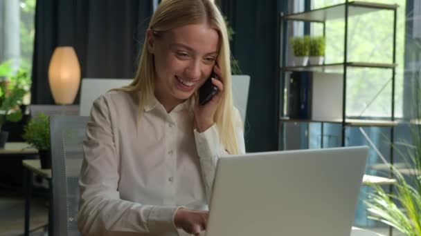 快乐的白种人女商人交谈电话交谈咨询客户商务在办公室微笑的女士多任务工作使用手提电脑检查文件在桌上支持客户移动电话 — 图库视频影像