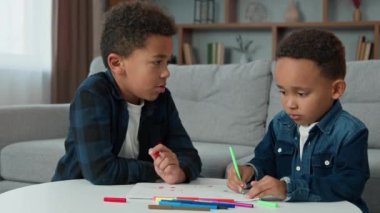 İki etnik Afrikalı Amerikalı çok ırklı çocuk, çocuklar, öğrenciler, çocuklar, çocuklar, renkli kalemlerle çizimler, ev kardeşleriyle konuşmak, renkli keçeli kalemlerle resim çizmek.