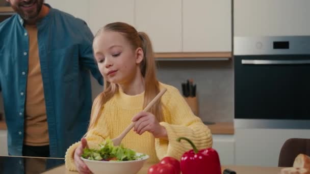 ベジタリアン新鮮な健康的な料理の夕食サラダミックス野菜を調理する10S小さなコーカサスガールの子供子供は 家庭のキッチンで父親の大人の男ハグカドル娘の幸せな家族を調理します — ストック動画