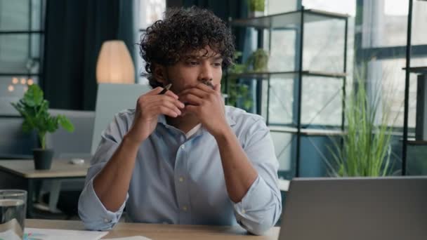思慮深い男のアラビアのインドのビジネスマン雇用主のマネージャーは ノートパソコンのペンシング思考で働いています 考える ビジネス問題解決 オフィスの創造的なコンピュータ作業 疑問を考える — ストック動画