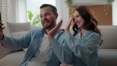 Kafkasyalı mutlu çift selamlaşırken başparmak kaldırıyor sohbet görüntülerini gösteriyor cep telefonu konferansı sohbet blogu sosyal medya blogu yazarları akıllı telefon uygulaması ile evde konuşuyor
