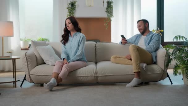 白种人夫妇在沙发沙发上家庭问题家庭问题麻烦生气的女人女朋友妻子生气的冒犯了丈夫男友男人沉迷于手机社交媒体的大笑 — 图库视频影像