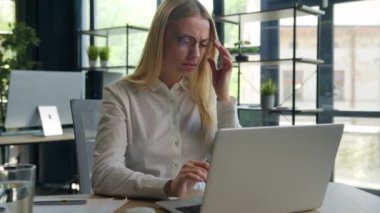Ofisteki yorgun Kafkasyalı iş kadını göz yorgunluğu çekiyor. Dizüstü bilgisayar işinden yorulmuş, hırçın gözler ovalanıyor. Gözlükler kötü görüş, gerilim baş ağrısı.