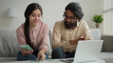 Arap erkek Hintli çok ırklı çift, evde Euro banknotlarını sayıyor maaş planlama aile bütçesi para hesaplama iç finansman hesapları, dizüstü bilgisayar finans ekonomisi