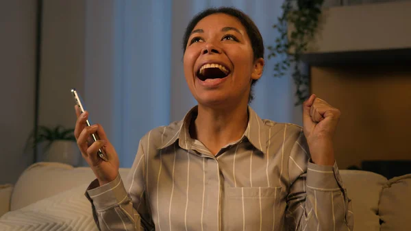 兴奋的非洲裔美国女人在移动应用中赢得了在线大奖快乐的少数民族女商人成年女性大喊着庆祝胜利的胜利电话彩票成绩晚上回家跳舞有趣 — 图库照片