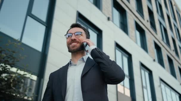 楽しい幸せな男コーカサス ビジネスマン 市内で携帯電話を話す 面白いケアフリー会話 男性ビジネス 雇用主 オフィスワーカー オフィス会社の近くで笑っている携帯電話を話す — ストック動画