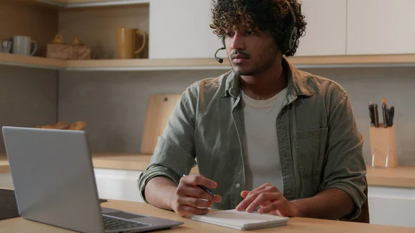 Hombre Indio Con Auriculares Sentado Cocina Estudiando Notas Escritura Línea —  Fotos de Stock