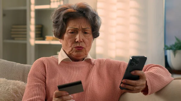 コーカサス古い女性引退したシニア女性成熟した女性のおばあちゃんバイヤーの顧客問題オンライン支払いショッピングの失敗デビットカードと携帯電話のエラーミス失敗した購入トラブル — ストック写真