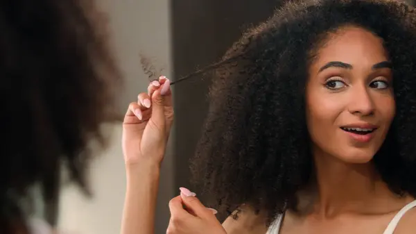 非洲裔美国女人正确扭曲卷曲女孩镜像反射触摸卷发享受健康的护发卷曲准备在早上美容常规享受洗发水型护发素 — 图库照片