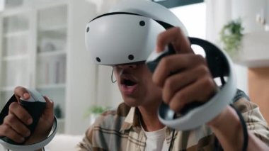 Heyecanlı mutlu Afro-Amerikalı adam sanal gerçeklik oyunu oynuyor ev tatili hobisi modern teknoloji oyun VR gözlüklü siber uzay deneyimi video bilgisayar 3D dünya bilgisayarı