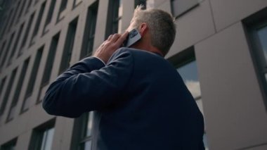 Geçmişe dönüp baktığımızda tanınmayan girişimci dışarıda çalışan olgun bir iş adamı ofis inşaatında emlakçılık yapan emlakçıya bakıyor cep telefonu görüşmeleri şehirdeki iş adamlarıyla konuşuyor.