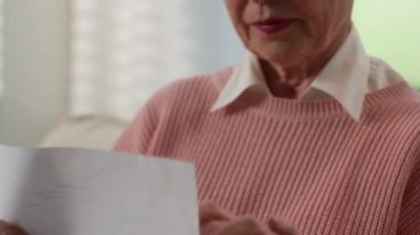 Kafkasyalı yaşlı kadın emekli yaşlı kadın üzgün olgun büyükanne üzgün evde kötü haberler okuyor endişeli banka borcu uyarısı yüksek vergiler mali sağlık sorunlarını engelliyor