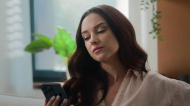 Beyaz kadın cep telefonlarını karıştırıyor akıllı telefonlara olumsuz cevap veriyor ev işkadınının evindeki cep telefonunda hayal kırıklığına uğramış kadın sohbet uygulaması üzgün üzgün üzgün üzgün üzgün üzgün hayal kırıklığı yaşıyor.