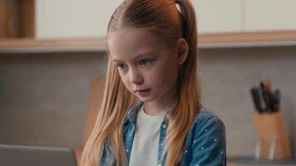 白种人小女孩在家里的厨房里带着笔记本电脑独自一个小女孩在玩计算机电子学习游戏学习远程教育玩网络空间Pc上网学习女儿 — 图库视频影像