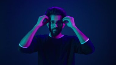 Neon Stüdyosu ultraviyole arka planlı Müslüman portresi. Hintli adam zihin patlaması yapıyor. Siber uzay hackleme programlama sorunu.