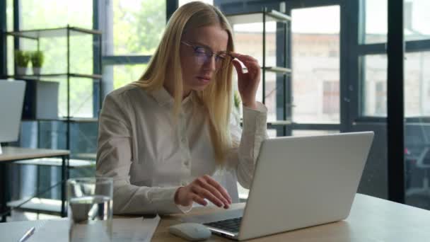 混淆不清的白人女商人在办公室用笔记本电脑工作的女商人女雇员眼镜片超负荷工作摘下眼镜检查视力不好视力模糊视力问题眼疲劳 — 图库视频影像