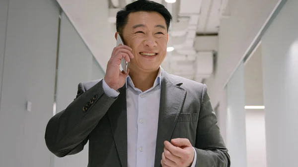 Orta Yaşlı Asyalı Adamı Ofis Koridorunda Cep Telefonuyla Konuşan Akıllı — Stok fotoğraf