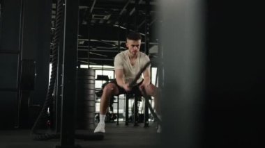 Etkin güçlü kas fitness eğitmeni Kafkas erkek sporcu vücut geliştirme antrenmanı savaş halatları yoğun kardiyo çalışması fiziksel dayanıklılık spor vücut geliştirme beden eğitimi