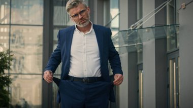 Beyaz, olgun, üzgün, yaşlı iş adamı gösterisi. Boş pantolonlar, iflas, yoksulluk, küresel ekonomik kriz, finans işvereni eksikliği. Açık havada girişimcilerin iflas borçlarını altüst ediyor.