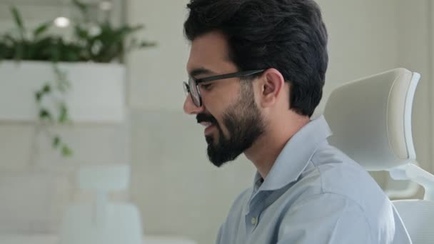 移動ショット アラビアのインドのビジネスマンの笑顔の男 ラップトップの男性ビジネス雇用主プログラマコーディングコンピュータプログラムソフトウェア オフィスのテーブル上の携帯電話とのプロジェクトのリモートジョブをタイプする — ストック動画