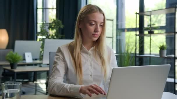 ビジネスポートレート コーカサス州の若い女性 Gen 学生の女ビジネスマン 会社のオフィスでコンピュータの電子ラーニングと仕事場で笑顔のカメラの女性経営者を見ている — ストック動画