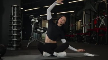 Fit, ince, beyaz, sporcu, sağlıklı, aktif, vücut kaslarını esneten, Lotus pozisyonunda esneme egzersizi yapan sporcu, spor salonu antrenörü, yoga sporu antrenmanı yapan, spor antrenörü.