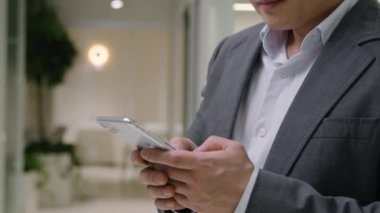 Vurulan Asyalı yetişkin işadamı üzgün Koreli etnik adam cep telefonundan kötü haberler okuyor cep telefonundan endişeli erkek işveren cep telefonu sorunu ofis kazasında başarısız oldu