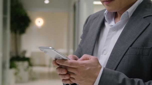 移動ショット アジアの成熟したビジネスマン 中国の韓国人 チャット 悪いニュース 携帯電話のスマートフォン 不安な男性 ビジネス 雇用主 携帯電話の問題 — ストック動画