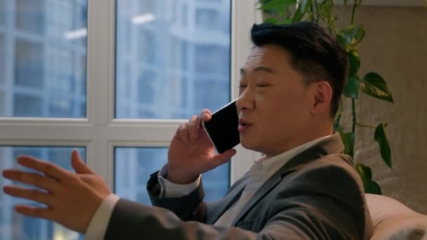 アジアの成功したビジネスマン韓国の民族男性は 中国の男性中年雇用主Ceoマネージャー笑顔の現代オフィス会社で携帯電話を呼び出します スマートフォン 屋内ビジネス会話交渉 — ストック動画