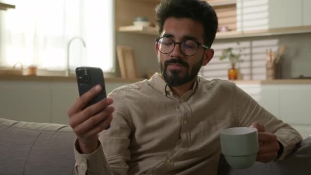 Розслабляючий Арабський Чоловік Чоловік Етнічний Хлопець Зручному Дивані Використанням Мобільного — стокове відео