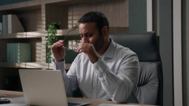 疲れた男アラビアの疲れたビジネスオフィスワーカーのビジネスマンは 乾燥したかゆみを伴う目をマッサージする眼鏡を取り除きます 疲労疲労頭痛 閉じるラップトップコンピュータ仕上げ作業を完了 — ストック動画