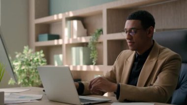 İş yerindeki belgelerle çalışan Afro-Amerikalı bir adam. Erkek işadamı, CEO müdürü, girişimci, profesyonel yönetici, araştırma verileri, internet üzerinden daktilo işletme projeleri üzerine çalışıyor.